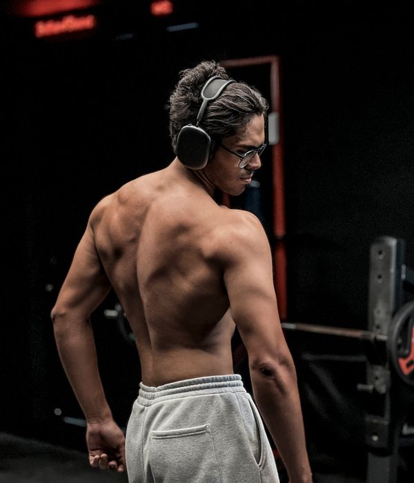 Man performing a controlled strength exercise in a modern, dark gym.